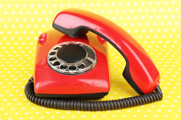 Red retro telephone on bright background