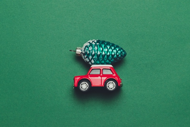 Red retro toy car with Christmas or New Year delivery Christmas toy on a green background