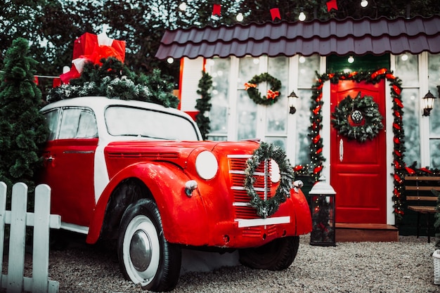 お祝いの装飾の赤いレトロなヴィンテージカー。メリークリスマス。