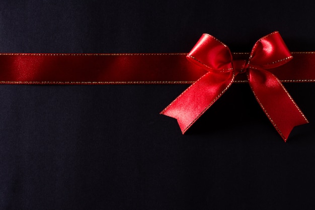 Red ribbon on black background with copyspace for text. Black Friday.