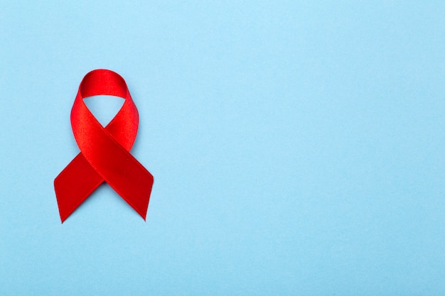 red ribbon on a dark gray background. symbol of The World AIDS Day or cancer or HIV Awareness Month and concept of healthcare. Copy space