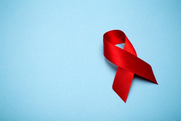 red ribbon on a dark gray background. symbol of the world aids day or cancer or hiv awareness month and concept of healthcare. copy space