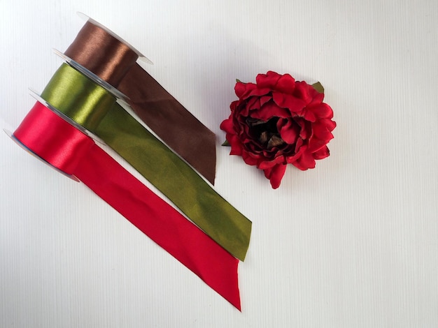 Red ribbon flower and satin ribbons on a white background