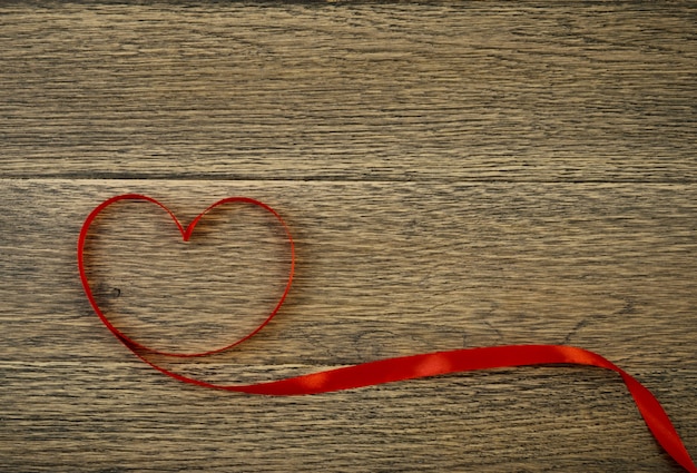 Red Ribbon Heart on Rustic Wood Background