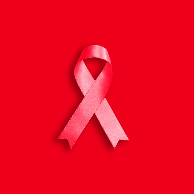 Red ribbon on a red background for the 1-st December, World AIDS day