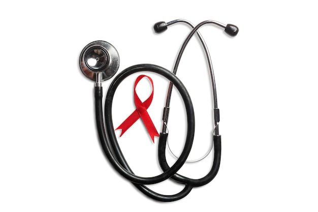 白い背景の赤いリボンと聴診器。 HIVエイズリボンの認識