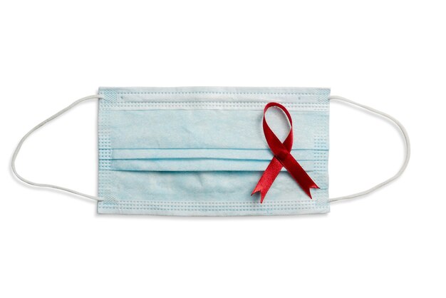 白い背景の赤いリボンと注射器。 HIVエイズリボンの認識