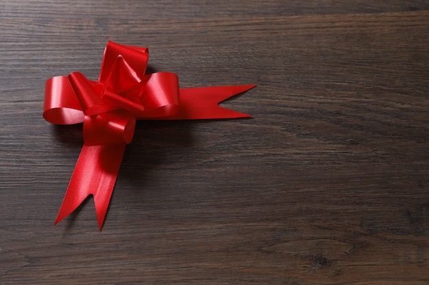 Red ribbon on wooden table.