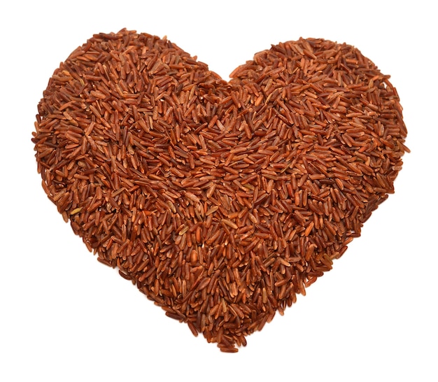 Red rice in the shape of heart isolated on white background. Useful dietary food. Love. Flat lay, top view