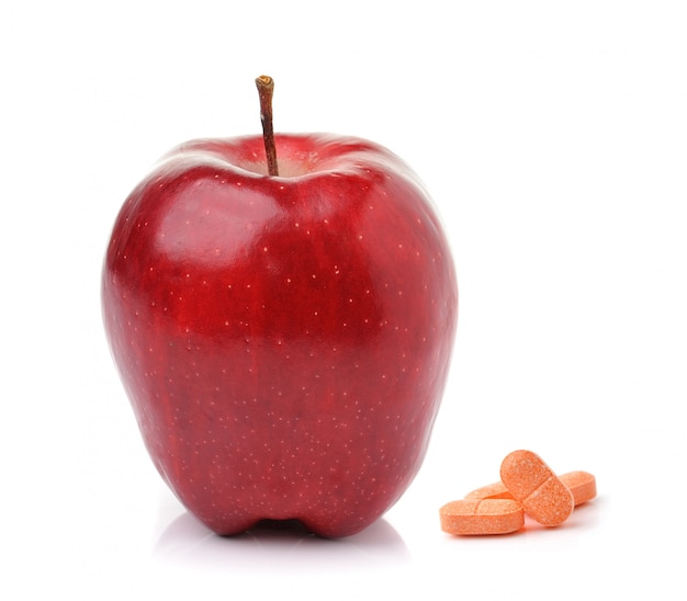 Red ripe apple  and pills capsules isolated on white 