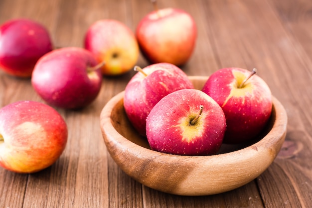 Красные спелые яблоки в деревянной миске