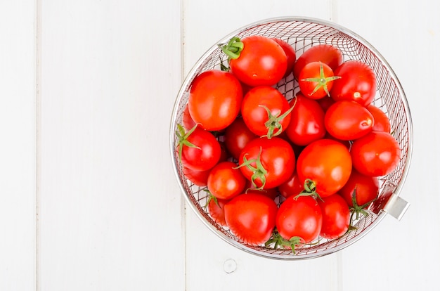 Red ripe cherry tomatoes on wooden table.