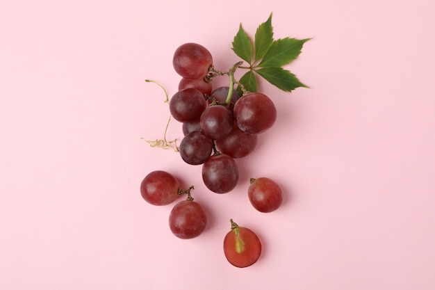 Red ripe grape on pink background, close up