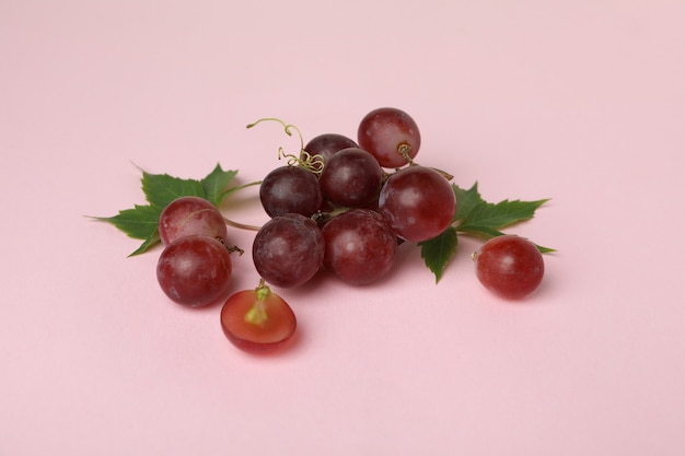 Red ripe grape on pink background, close up