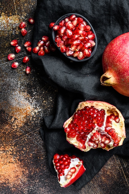 Red ripe pomegranate. Organic fruit. Black wall. Top view.