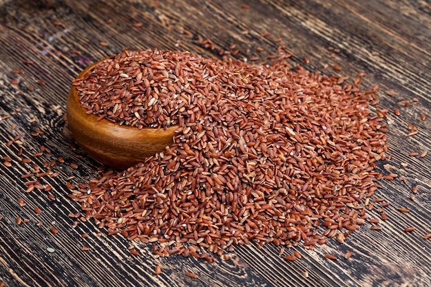 写真 穀物の有益な特性を維持するために皮をむいていない赤熟した米、生の未調理の赤米