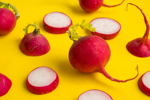 Red ripe sliced radish on yellow background