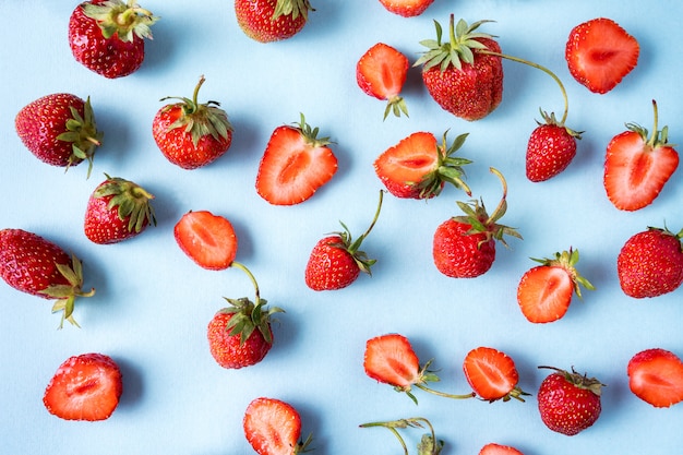 Red ripe Strawberries pattern over blue 