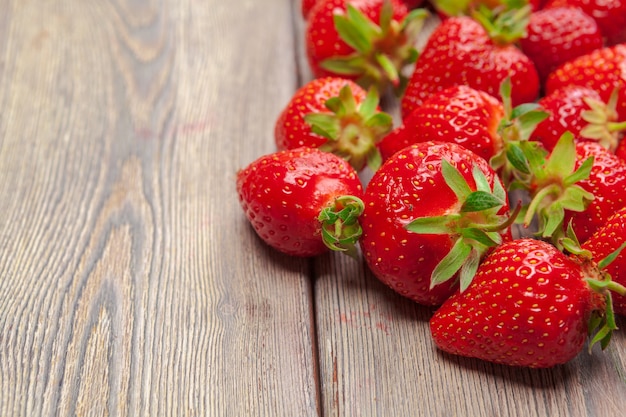 Red ripe strawberries on wooden table close up