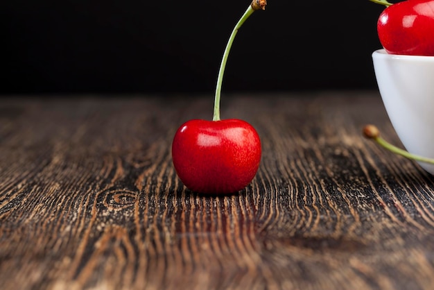 Photo red ripe sweet cherries on a wooden table