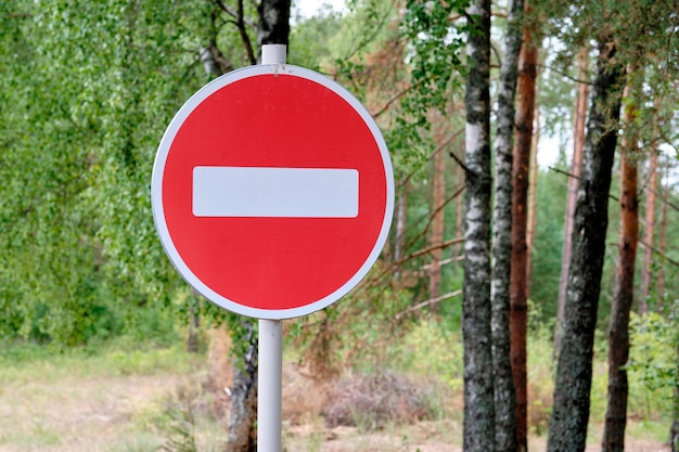 Photo red road sign entry is prohibited against the background of the forest closeup