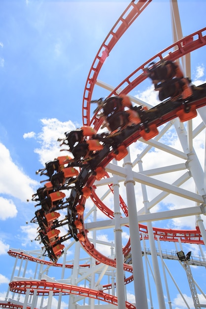 Red roller coaster rail with blue sky in background