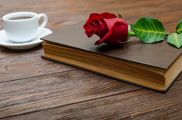 Photo a red rose on a closed book