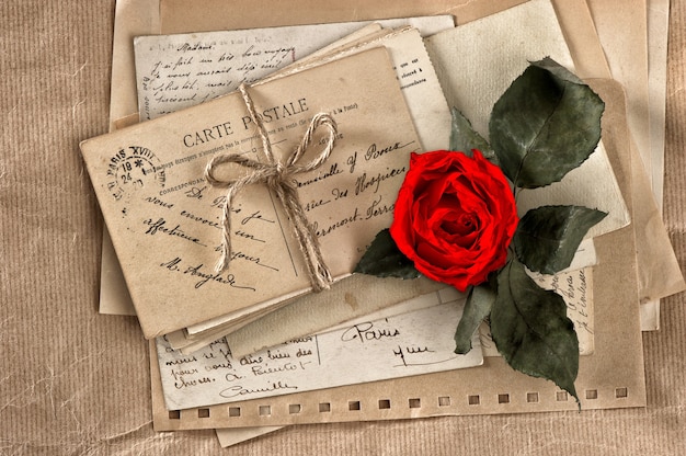 Red rose flower and old letters. vintage postcards and papers. scrapbook