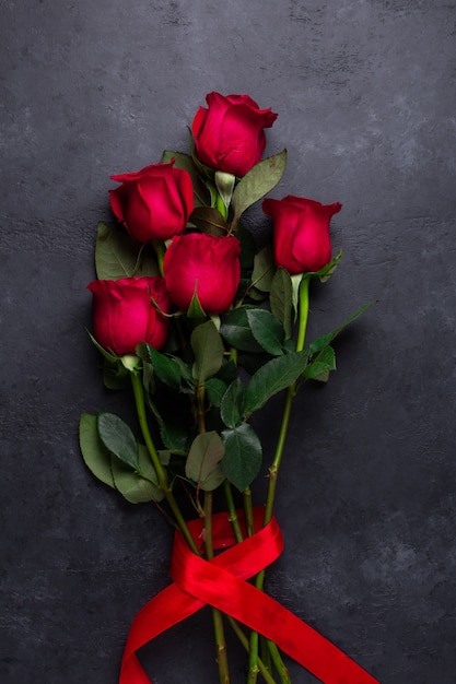 Foto mazzo dei fiori della rosa rossa su pietra nera. biglietto di auguri di san valentino