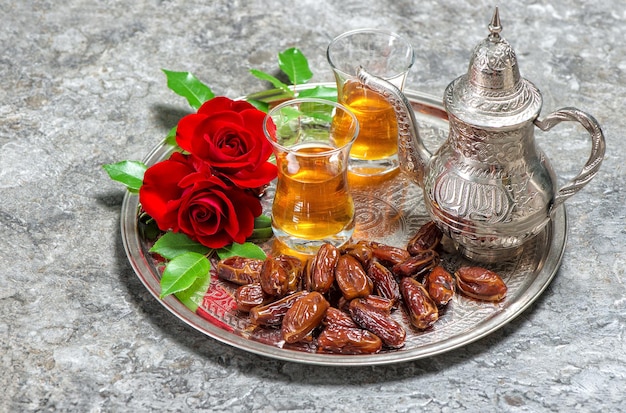 Red rose flowers with tea and dates fruits Islamic holidays Ramadan