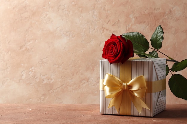 Red rose  and gift box on textured background