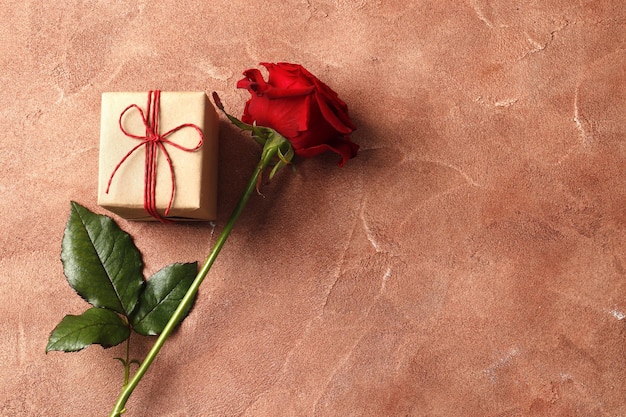 Red rose  and gift box on textured background