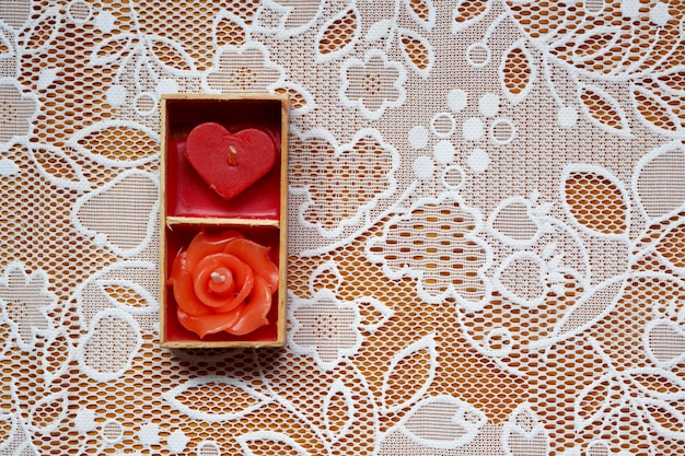 Candela rossa del cuore della rosa su una priorità bassa del tessuto del pizzo il giorno di san valentino