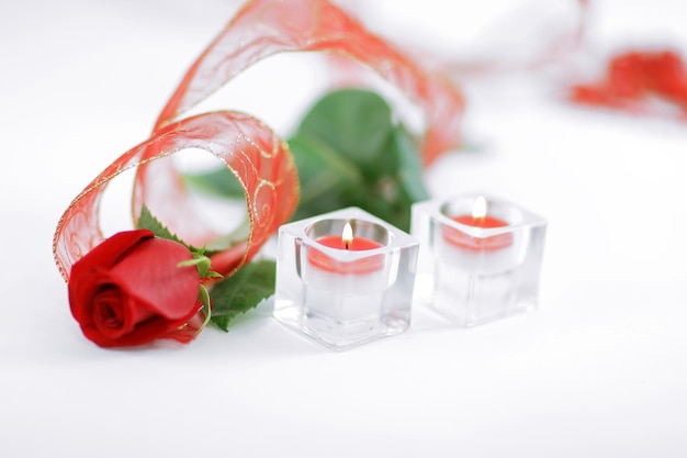 Red rose and a pair of candles on a white backgroundphoto with