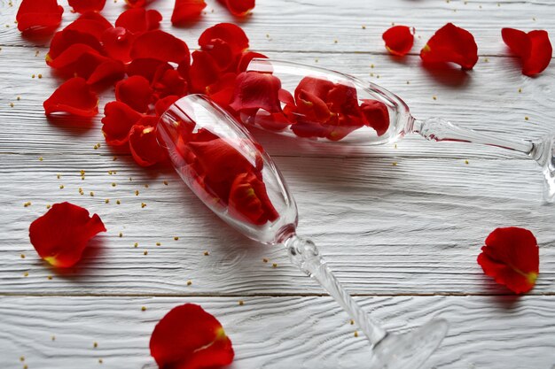 Red rose petals spilled out of wine glasses. Valentine's Day concept