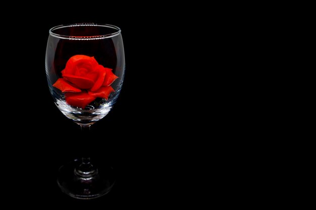 Photo red rose in wine glass