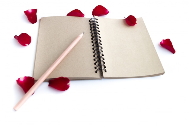 Red rose with petals and brown notebook 