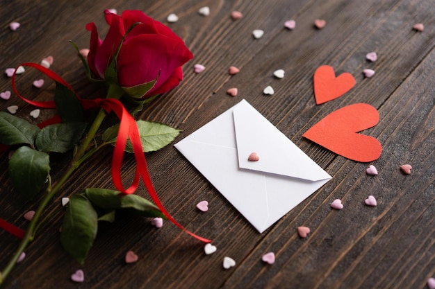 Red rose with postcard on wooden background Happy Valentines Day postcard Love concept for mothers day or valentines day Valentine card with space for text