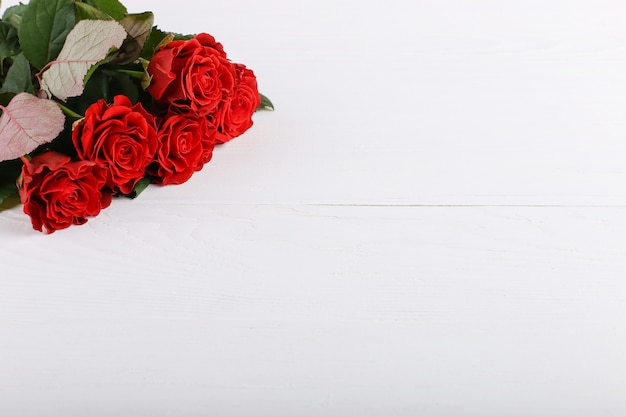 Red roses bouquet on a white wooden table