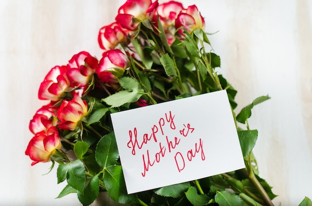 Photo red roses and card with text happy mothers day