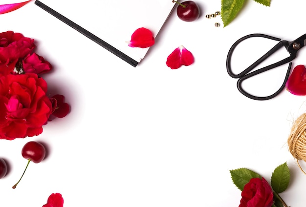 Red roses, cherries and scissors isolated closeup