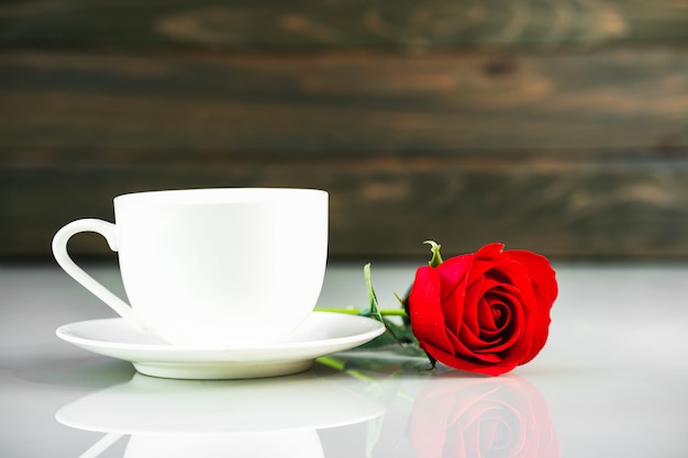 Red roses and coffee cup on table