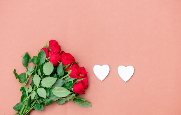 Red roses and heart shapes on pink