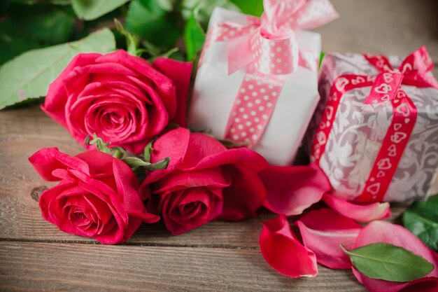 red roses and holiday gift on a wooden table