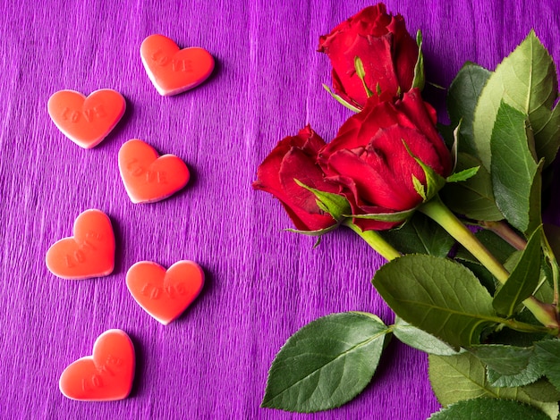 Red roses and red hearts on purple