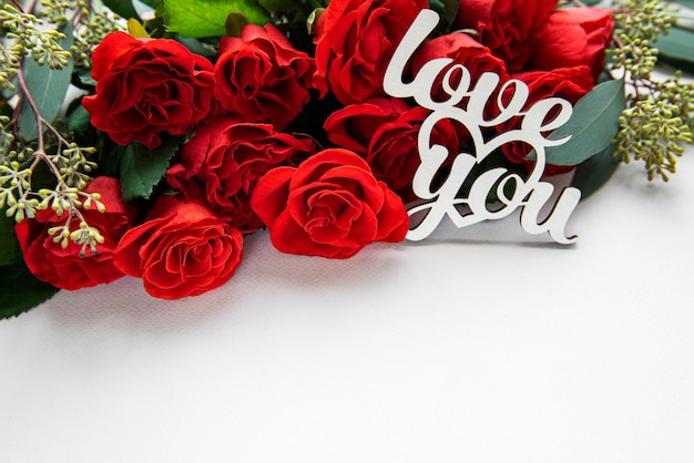 Красные розы с эвкалиптом с сообщением: люблю тебя