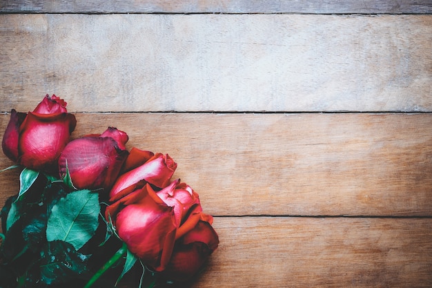 Red roses on wooden background