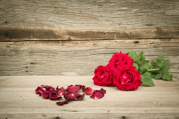 Photo red roses on wooden background