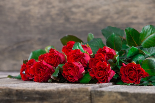 Foto rose rosse su tavola di legno