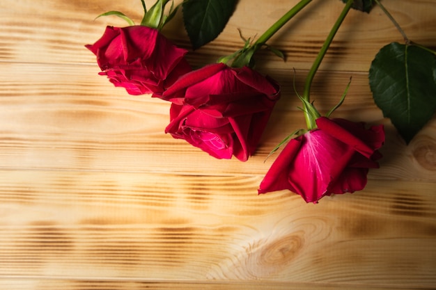 Red roses on wooden surface